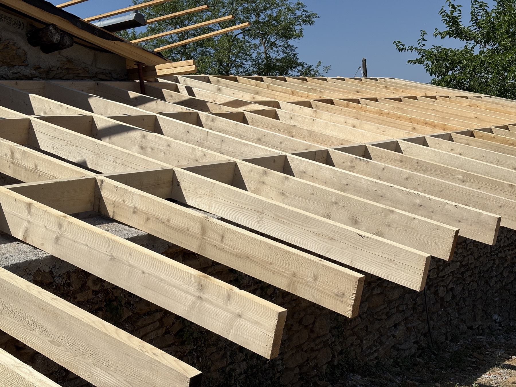 Charpente neuve en bois réalisée par C Habitat sur une toiture en rénovation