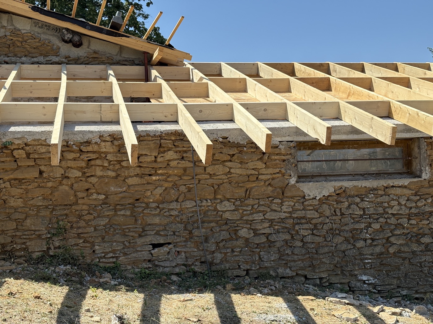 Structure de charpente en bois en cours de rénovation sur un bâtiment ancien