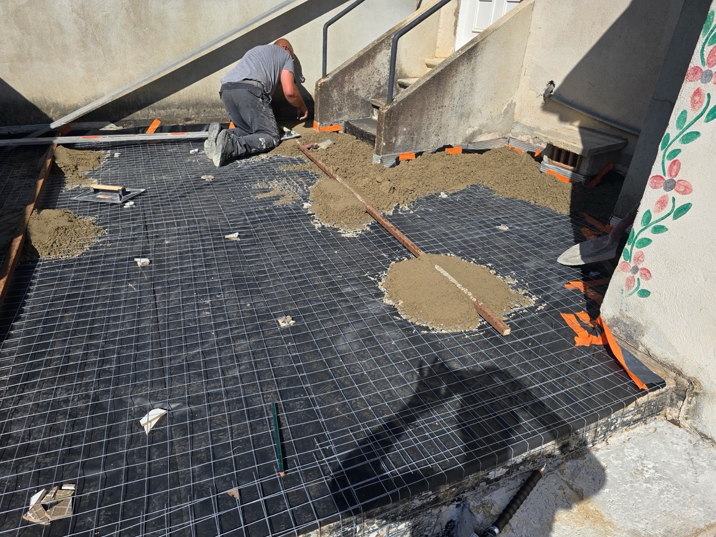 Préparation d’une toiture-terrasse avec trame et mortier pendant les travaux