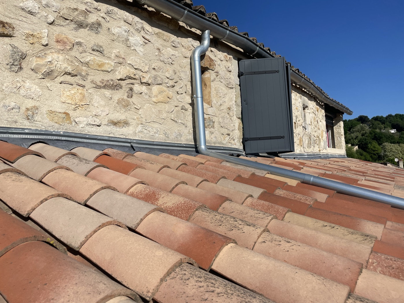 Artisan C Habitat réalisant un raccord de zinguerie sur une toiture